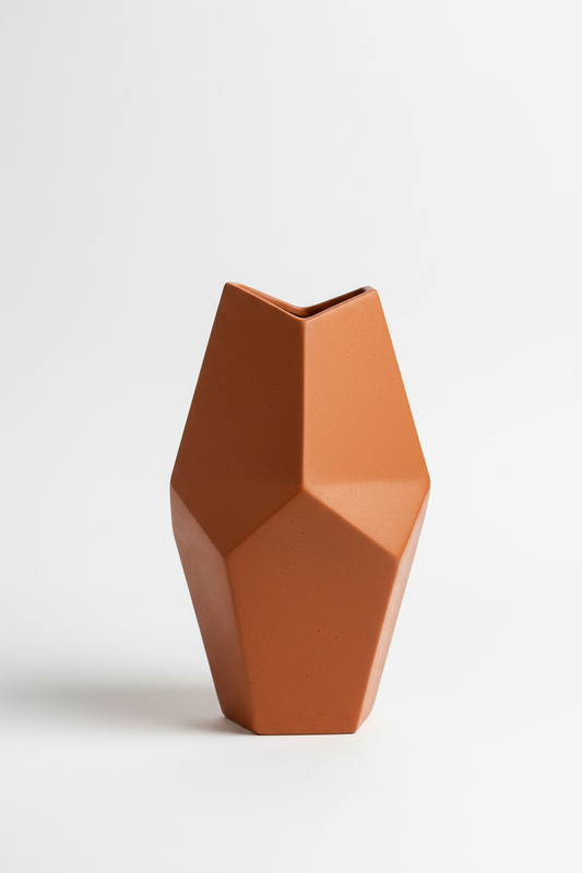 Terracotta geometric sculptural vase on white background